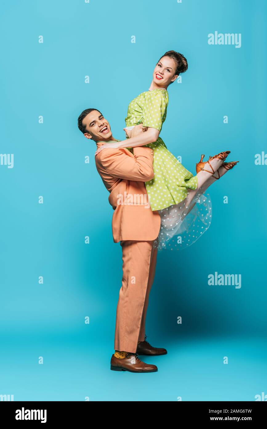 danseuse dansante tenant fille tout en dansant boogie-woogie sur fond bleu Banque D'Images
