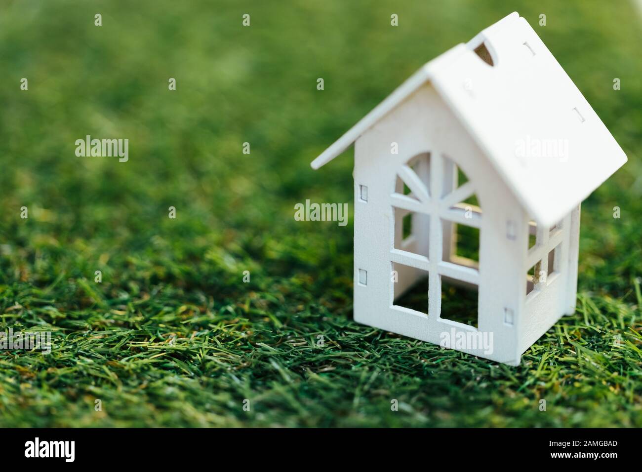 Maison miniature en bois blanc sur l'herbe verte. Investissement immobilier et immobilier immobilier financier concept immobilier. Banque D'Images