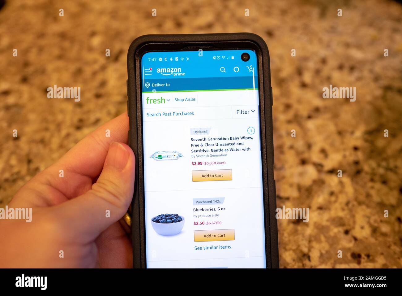Gros plan de main d'un homme utilisant l'application mobile Amazon pour acheter des fournitures ménagères auprès d'Amazon Prime, San Ramon, Californie, 22 novembre 2019. Modification de la note : image modifiée pour supprimer les détails d'identification de l'acheteur. () Banque D'Images