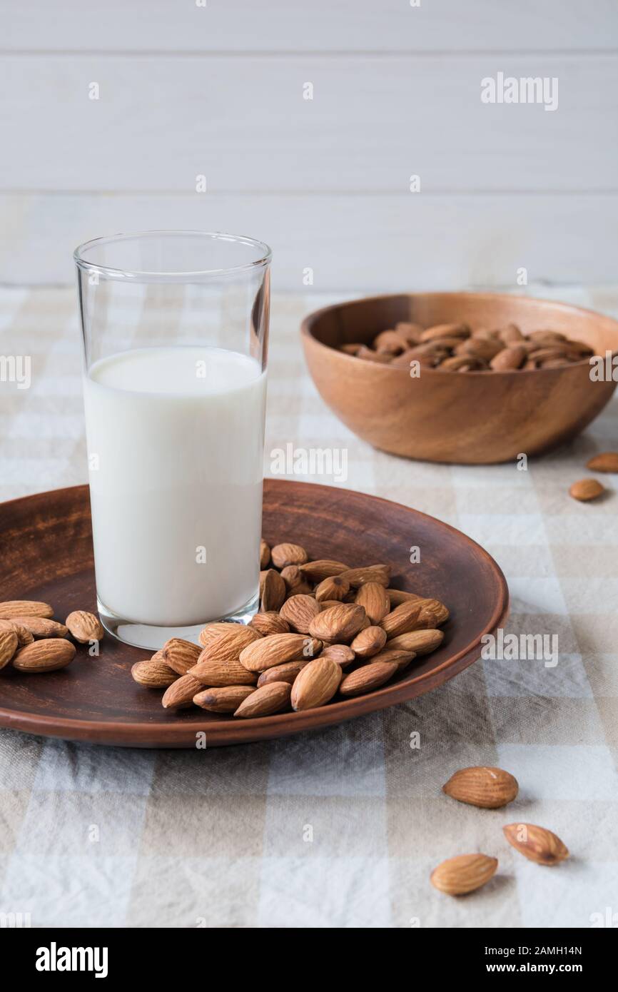 Concept d'aliments sains, les amandes et le verre de lait dans une assiette sur la table Banque D'Images