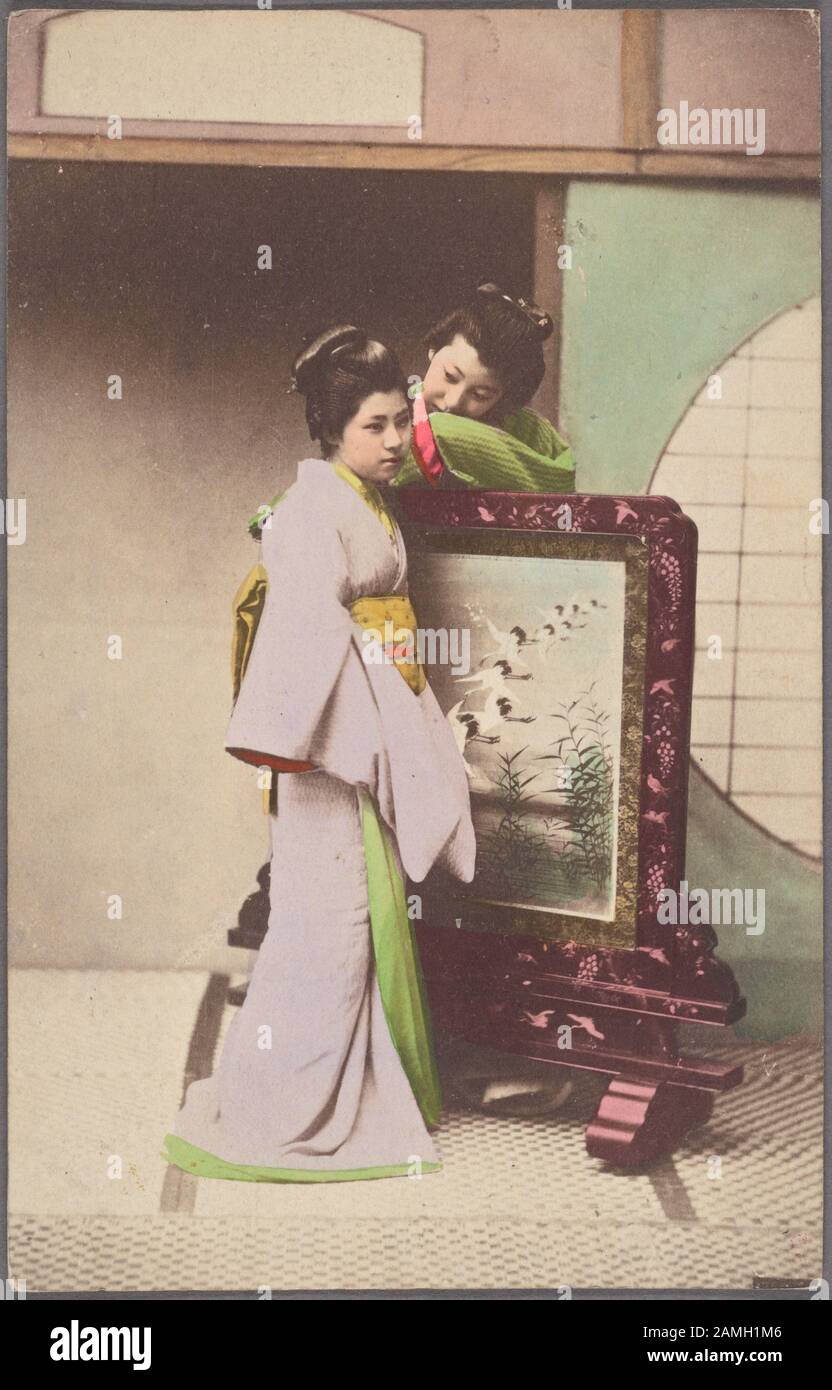 Carte postale illustrée présentant deux jeunes filles japonaises dans un kimono traditionnel posé par une peinture encadrée, publiée par Kanamaru, 1904. De La Bibliothèque Publique De New York. () Banque D'Images
