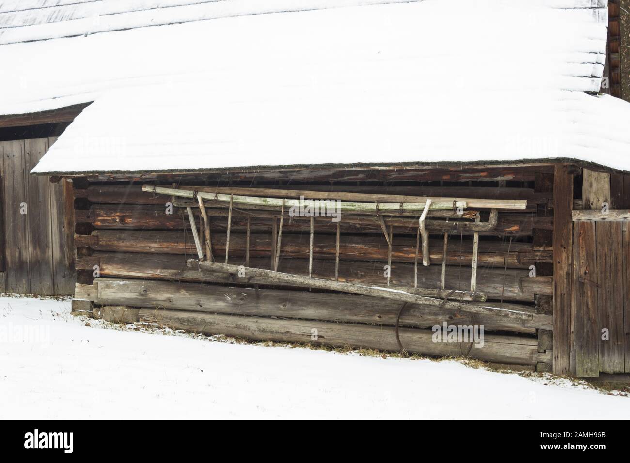 Ancienne échelle en bois rétro sur la cabine en bois en hiver. Banque D'Images