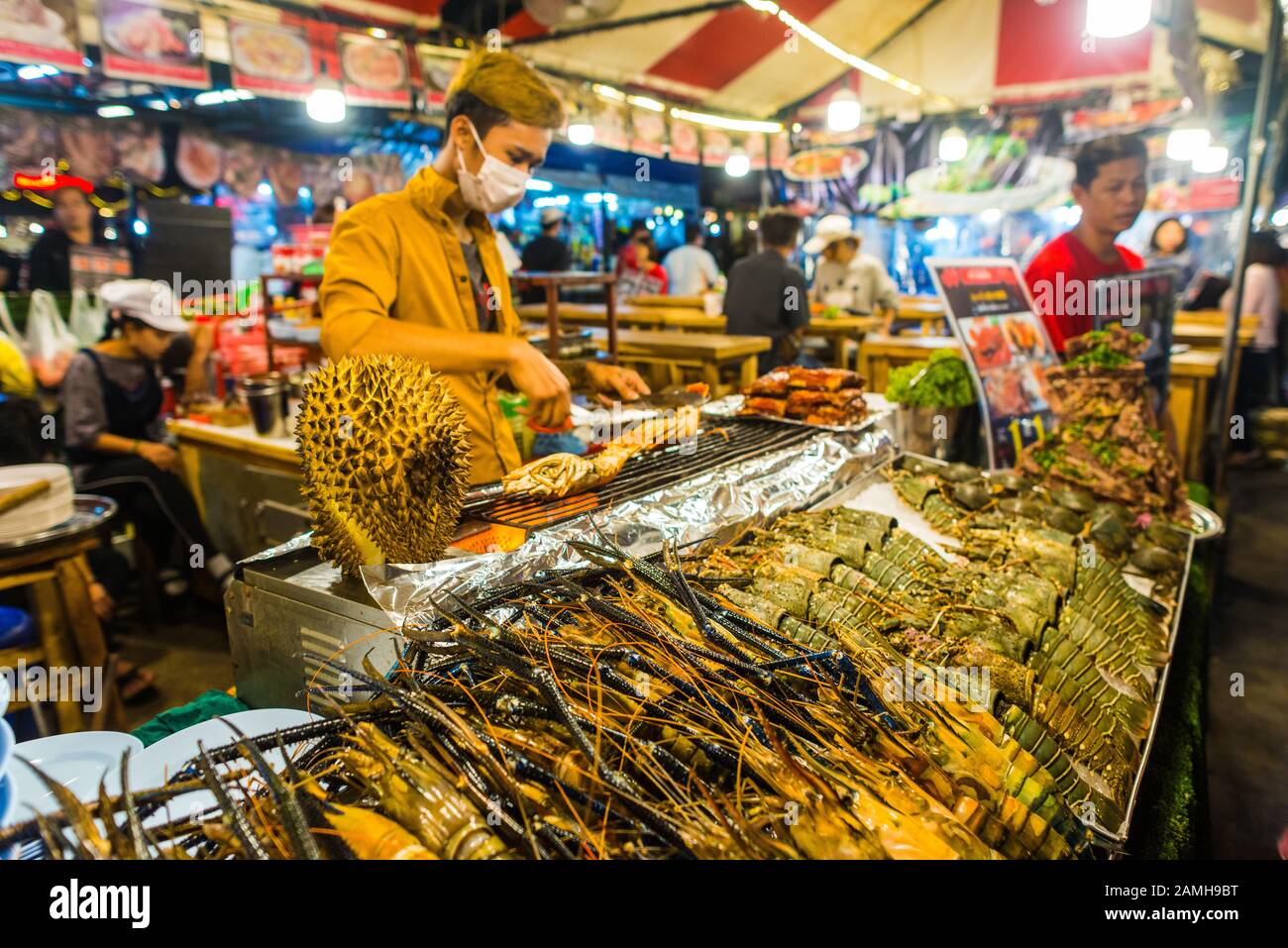 Bangkok/Thaïlande-05 décembre 2019: Scènes de Talat Rot Fai marché de la nourriture de nuit, homards bruts sur glace prêt à la vente avec un cuisinier en arrière-plan Banque D'Images