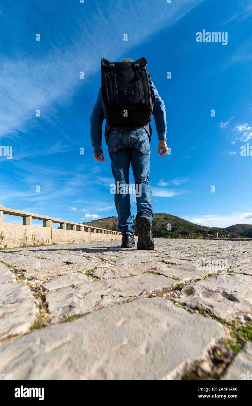 vue arrière d'un homme marchant avec un grand sac à dos Banque D'Images