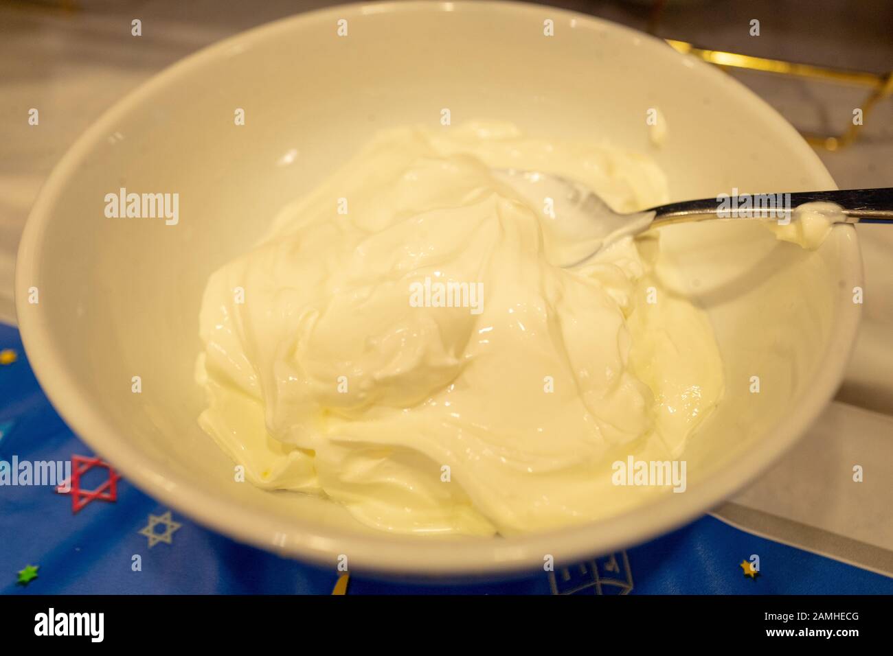 Gros plan sur un bol de crème sure, accompagnement traditionnel des lateaux de pommes de terre lors de la célébration traditionnelle des vacances juives de Chanukah (Hanoukkah), San Ramon, Californie, 15 décembre 2019. Les aliments frits sont souvent consommés en vacances pour commémorer le miracle de Chanukah, dans lequel l'huile a brûlé pendant 8 jours complets. () Banque D'Images