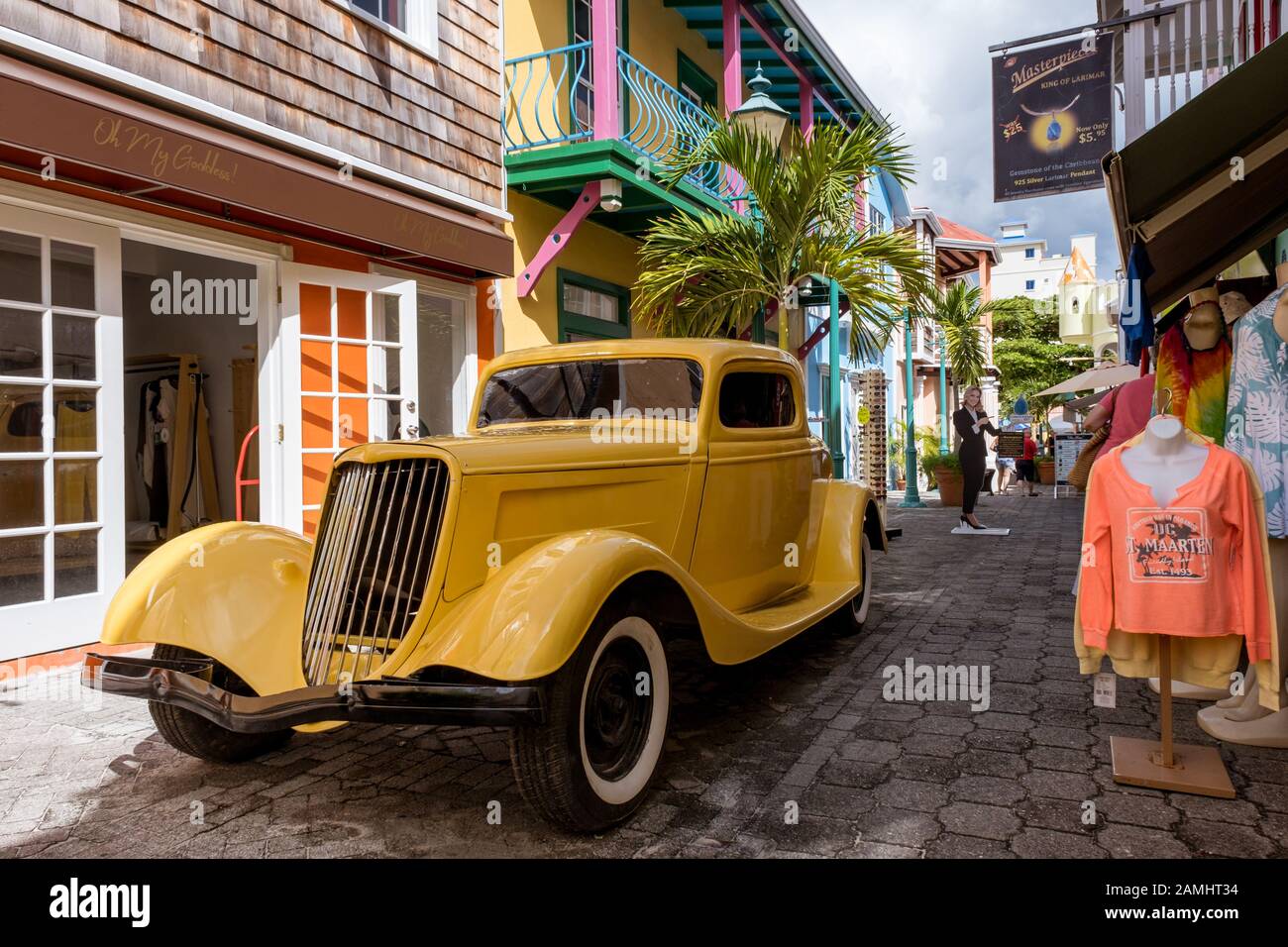 Une voiture jaune vintage sur Old Street à Philipsburg, Sint Maarten, Saint-Martin, Antilles néerlandaises, Antilles occidentales, Caraïbes. Banque D'Images