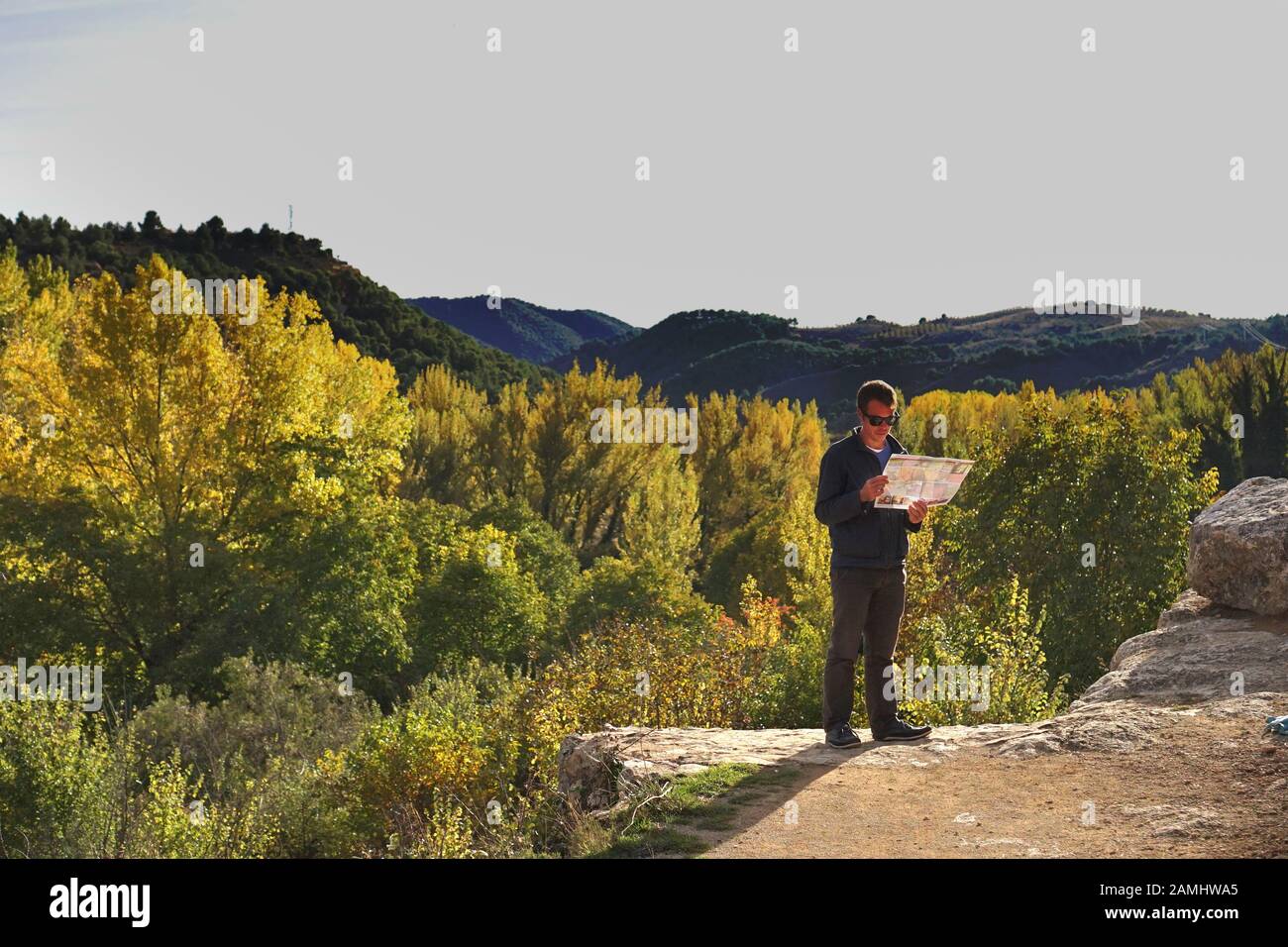 Un homme qui regarde une carte de voyage dans la campagne montagneuse d'automne espagnole Banque D'Images