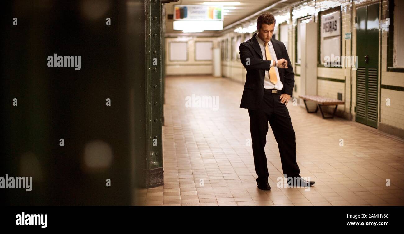 Vue latérale d'un homme qui attend dans une salle de métro. Banque D'Images