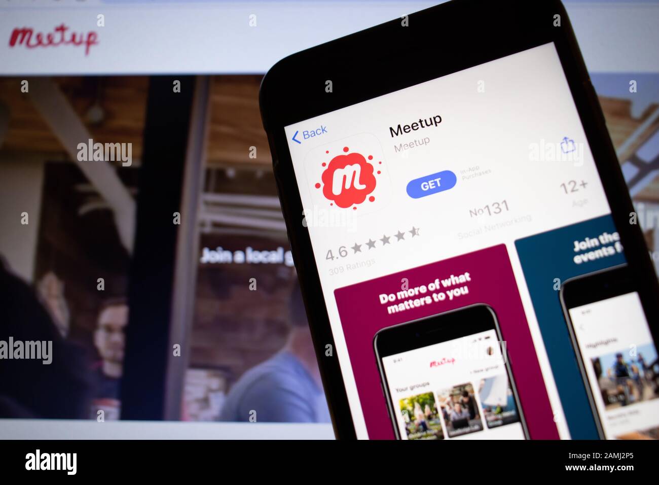 Saint-Pétersbourg, Russie - 10 janvier 2020: Téléphone mobile avec icône Meetup sur écran de gros plan avec site sur ordinateur portable, éditorial illustratif Banque D'Images