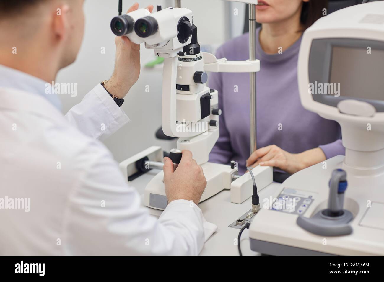 Portrait court de la jeune femme utilisant des machines pendant l'essai de vision dans la clinique moderne d'ophtalmologie, espace de copie Banque D'Images