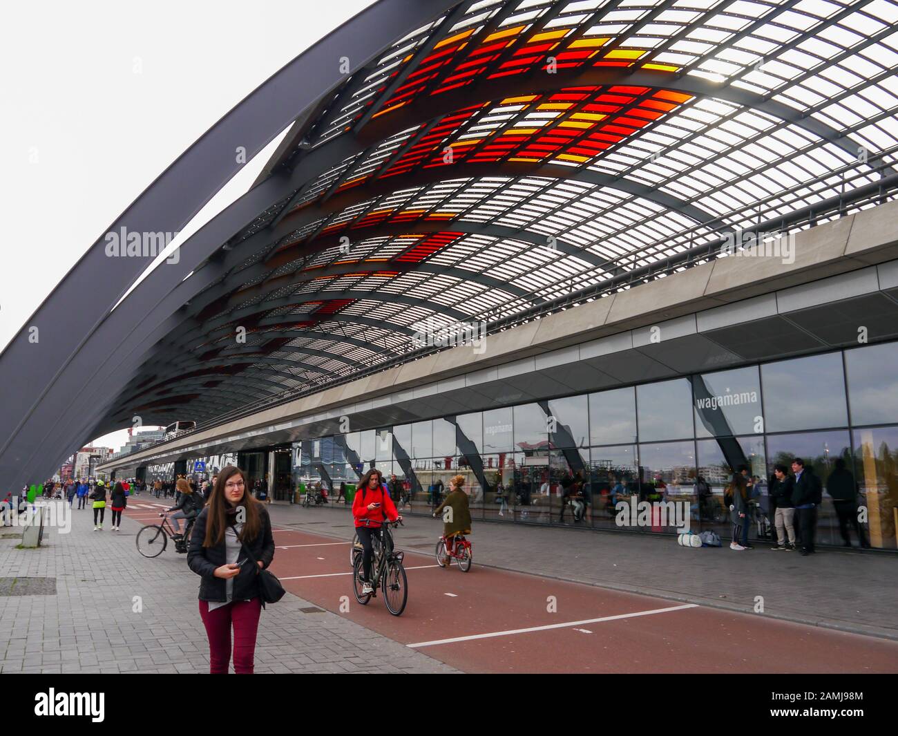 Vélos et piétons sous le vitrail couvert de la gare centrale d'Amsterdam Banque D'Images