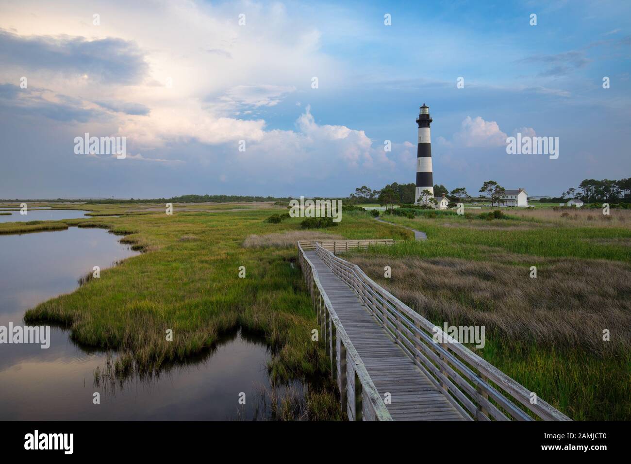 Coucher du soleil au phare de Bodie Island dans les Outer Banks, Caroline du Nord, avec promenade en bois en premier plan au-dessus du marais de l'océan Banque D'Images