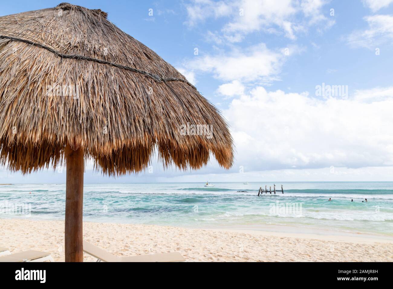 Gros plan sur la plage de paille de palmier de coco avec un ciel bleu et un espace de copie sur une plage de Cancun au Mexique. Banque D'Images