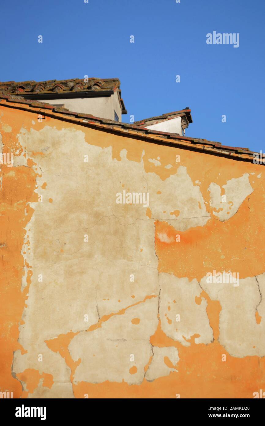 Paysage urbain caractérisé par un énorme mur jaune avec mortier endommagé par le temps contre le ciel bleu en arrière-plan Banque D'Images