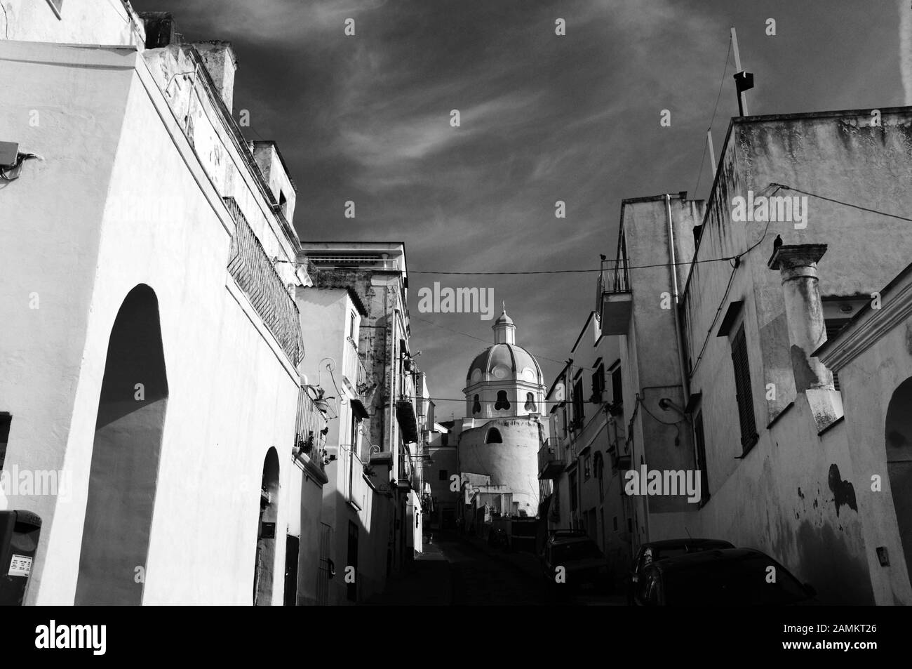 Rue dans le village de pêcheurs de Corricella avec vue sur une église. [traduction automatique] Banque D'Images