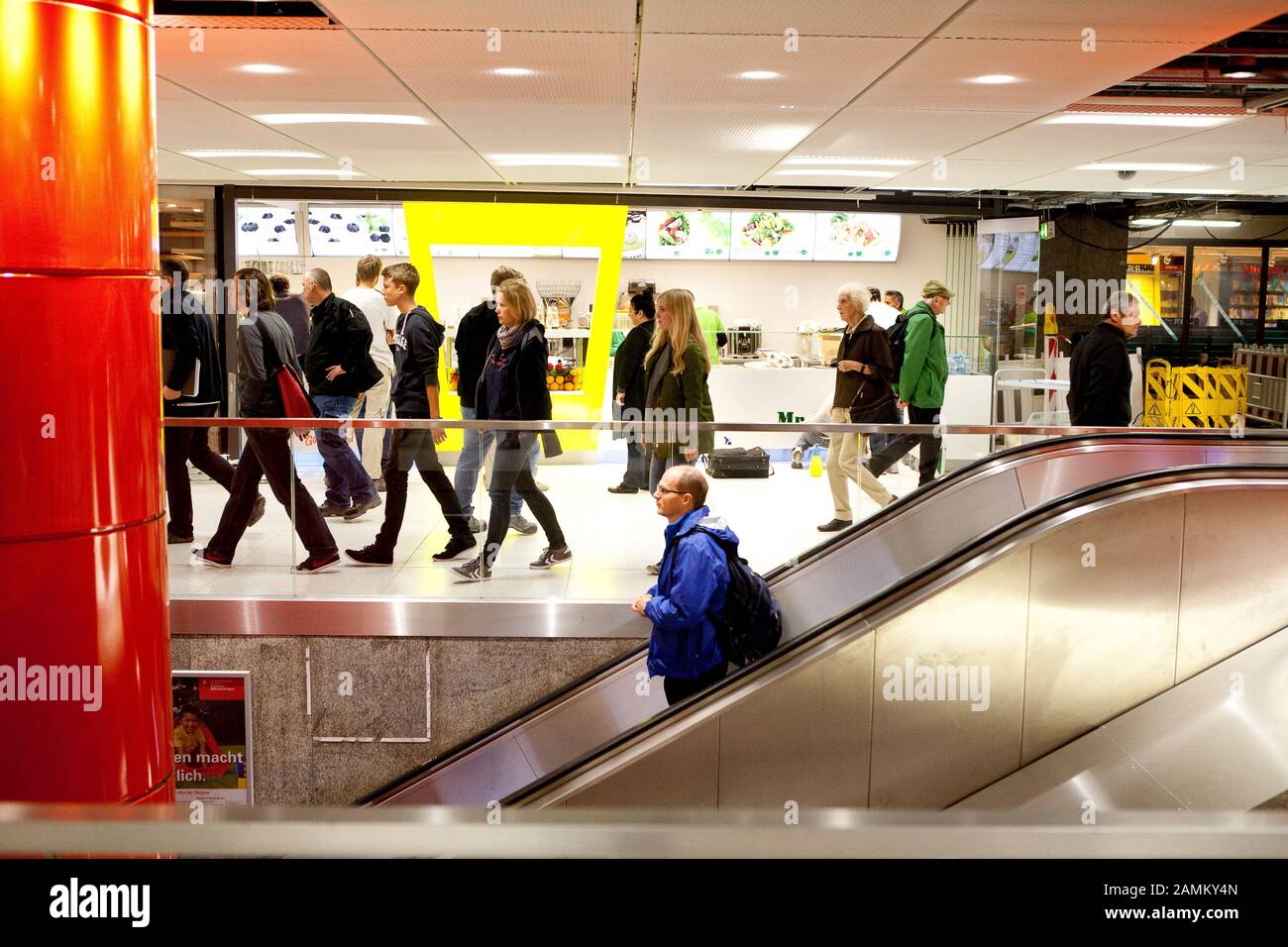 Mise en service partielle du nouveau niveau de distribution S-Bahn à la gare centrale de Munich : dans la photo passagers sur l'escalator, en arrière-plan une rangée de magasins. [traduction automatique] Banque D'Images