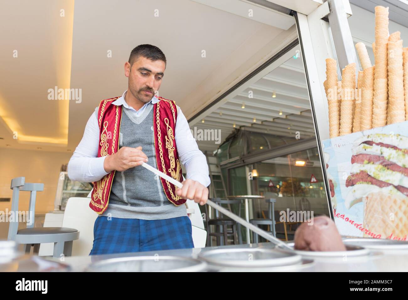 Le vendeur de crèmes glacées, vêtu de costumes traditionnels turcs, batterie les clients à Istanbul, en Turquie Banque D'Images