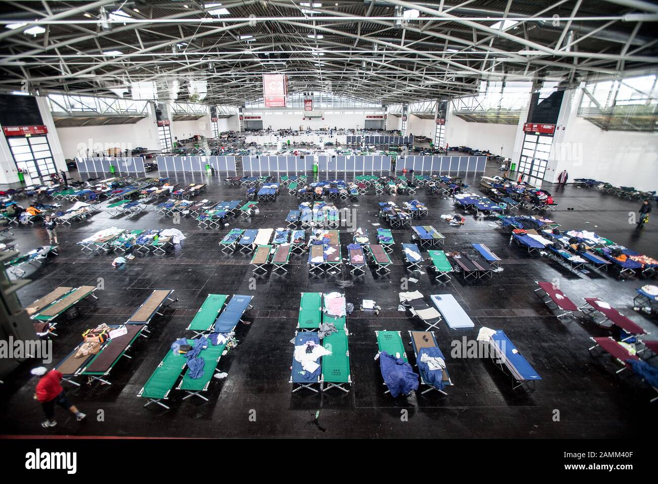 Hébergement temporaire improvisé pour les réfugiés dans une salle d'exposition à Riem : sur l'image, lits de camp pour les personnes fatiguées. [traduction automatique] Banque D'Images