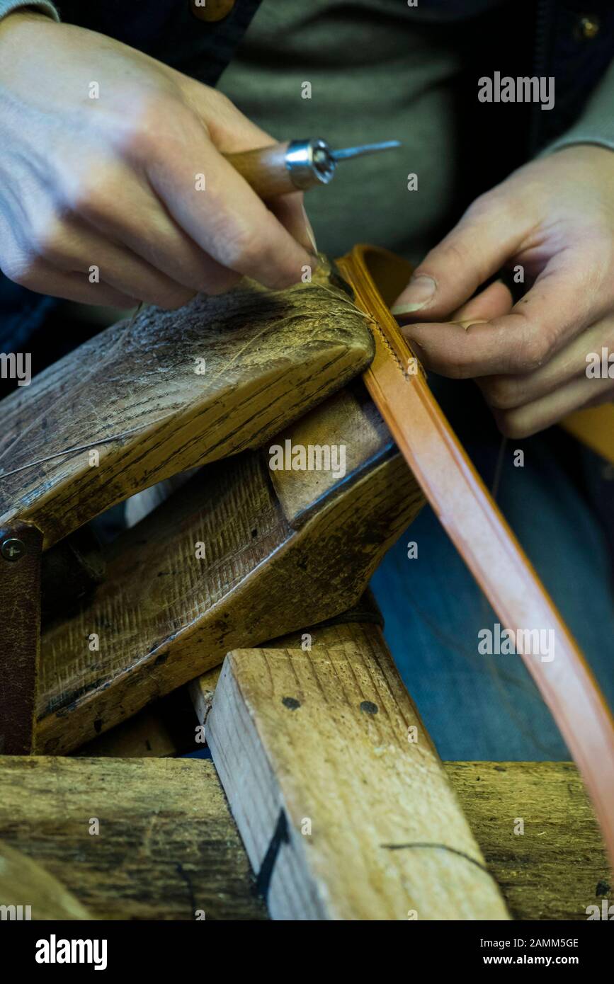 Saddler Beate Bader au travail dans son atelier à Aschheim près de Munich Dans la photo, elle cousu une couture de main avec deux aiguilles. [traduction automatique] Banque D'Images