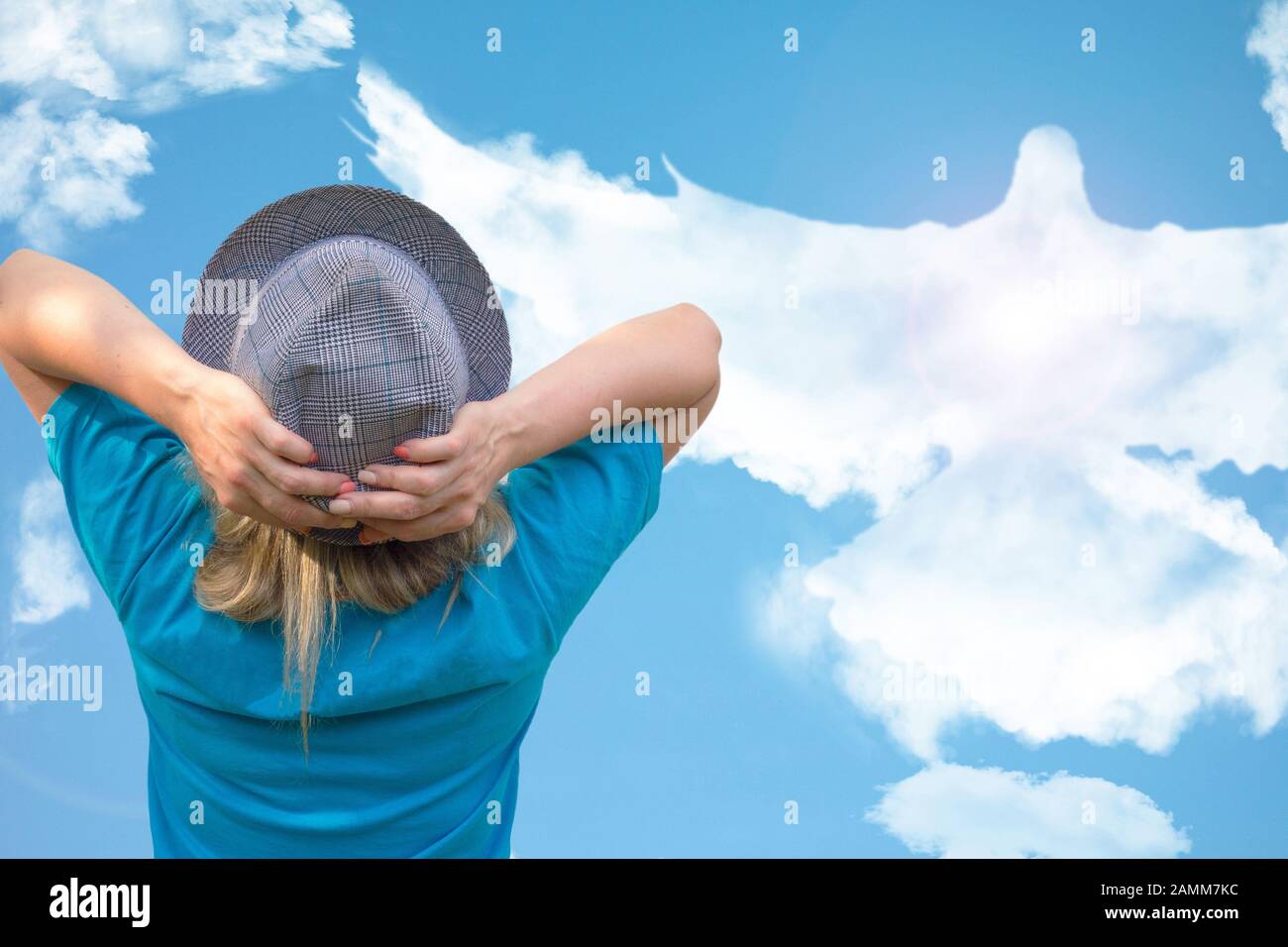 Fille en chapeau regarde grand oiseau de colombe en forme de nuage qui s'envole dans le ciel bleu. Concept d'amour, de romance et de relations heureuses. Ligne d'horizon pure et claire avec émotio Banque D'Images