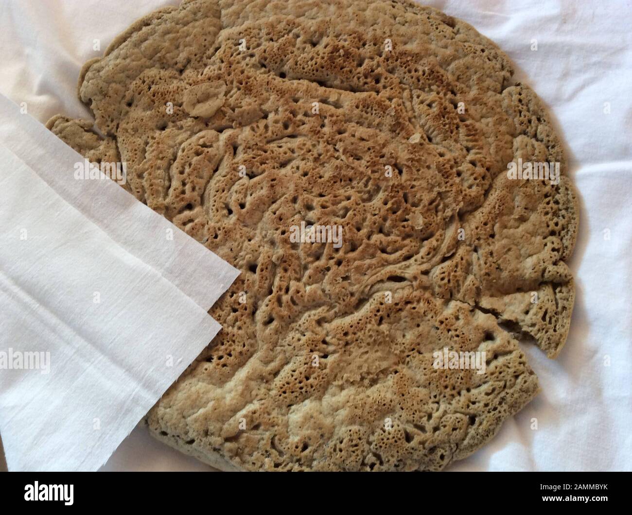 Pain injera à base de farine de thé. Teff également appelé millet nain, appartient à la famille de l'herbe douce. L'aire de répartition naturelle est en Éthiopie et en Érythrée, mais l'espèce est également cultivée dans d'autres régions tropicales et subtropicales. Les graines sont sans gluten et riches en acides gras essentiels. Ce type de millet est le grain le plus important en Ethiopie. Il est transformé en pain plat et en bière ou est également utilisé comme aliments pour animaux [traduction automatique] Banque D'Images