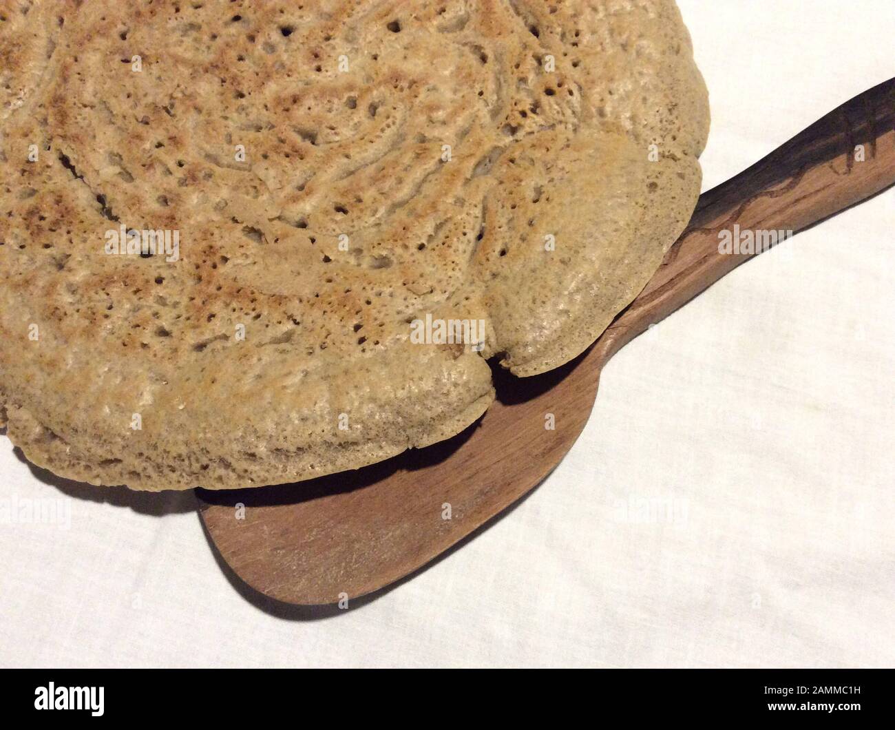 Pain plat injera à base de farine de thé. Teff également appelé millet nain, appartient à la famille de l'herbe douce. L'aire de répartition naturelle est en Éthiopie et en Érythrée, mais l'espèce est également cultivée dans d'autres régions tropicales et subtropicales. Les graines sont sans gluten et riches en acides gras essentiels. Ce type de millet est le grain le plus important en Ethiopie. Il est transformé en pain plat et en bière ou est également utilisé comme aliments pour animaux [traduction automatique] Banque D'Images