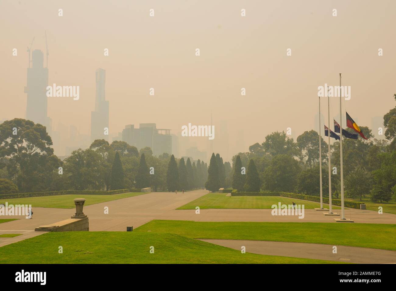 Drapeaux en berne avec la fumée provenant des feux de brousse dangereux santé couvrant la ville de Melbourne, Victoria, Australie Banque D'Images