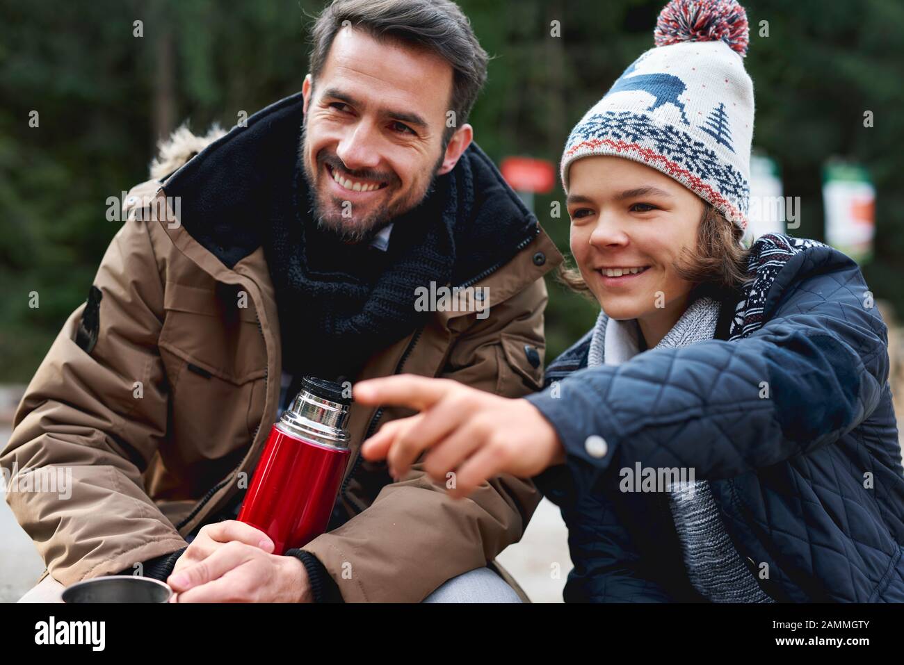 Le père souriant et son fils passent ensemble à l'extérieur Banque D'Images