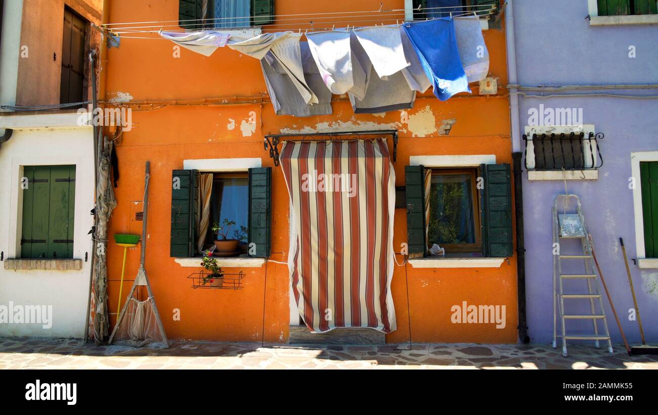 Façade en shabby de la vieille maison orange avec séchage de linge et équipement de pêche Banque D'Images