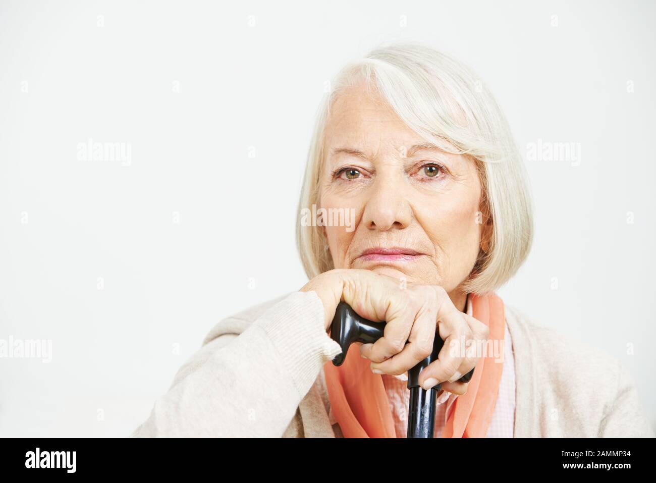 Une vieille femme avec un bâton de débrayage semble malheureusement dans l'appareil photo Banque D'Images
