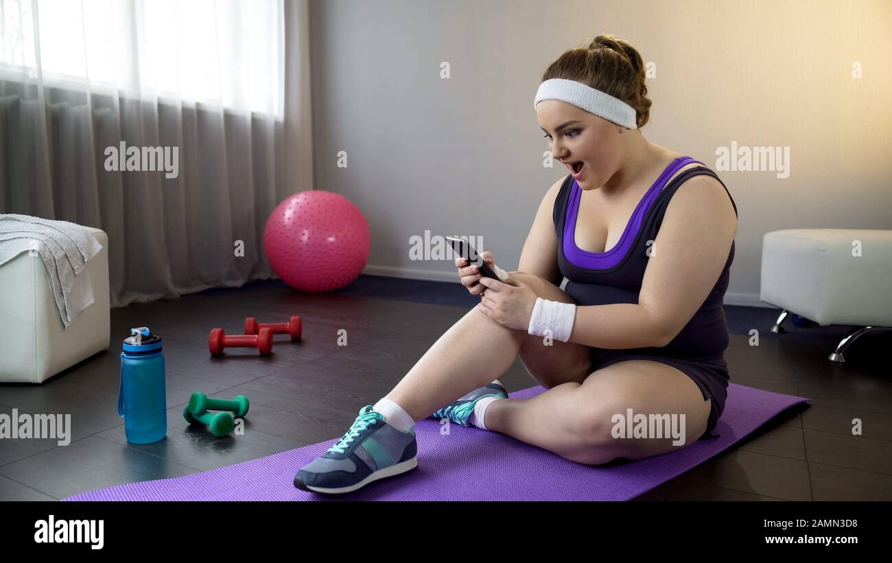 Lady vérifier sa perte de poids résulte en application sur smartphone, régime sportif Banque D'Images
