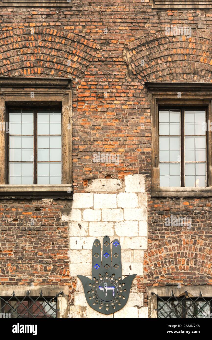 Hamsa sur le mur de briques de l'ancien bâtiment du quartier juif Kazimierz de Cracovie, Pologne Banque D'Images