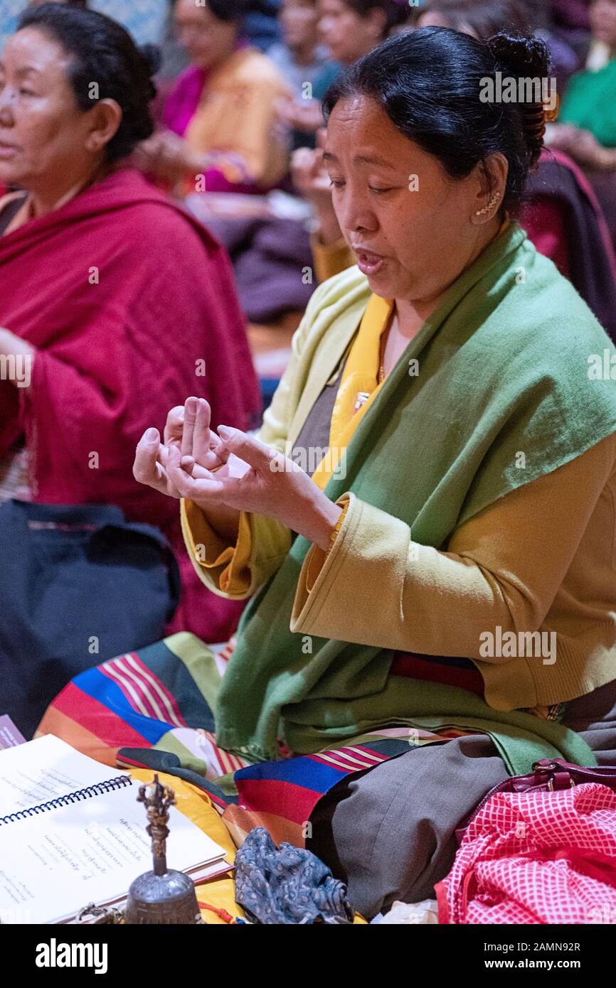 Une femme bouddhiste dévorée priant et méditant en étant assise et faisant les gestes appropriés de la main. Dans un temple à Queens, New York City. Banque D'Images