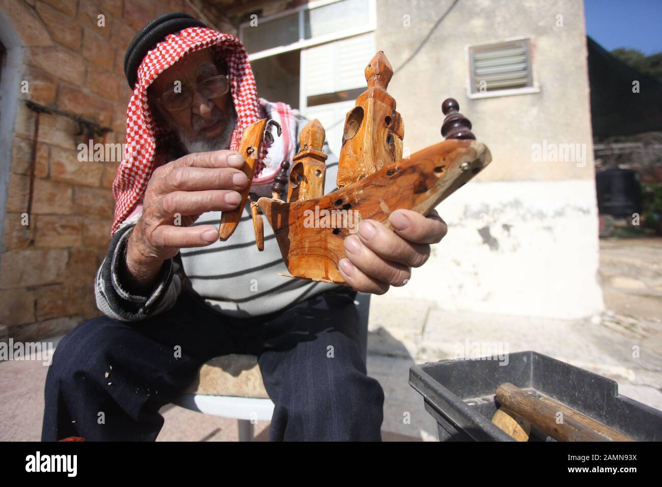 Jénine, ville de Jénine, en Cisjordanie. 14 janvier 2020. Le palestinien Mohammad Hussein présente une sculpture en bois faite par lui à sa maison dans le village D'A'nin, près de la ville de Jénine, dans le nord de la Cisjordanie, le 14 janvier 2020. Le travail principal de Mohammad Hussein, un ancien palestinien de Cisjordanie, est de sculpter du bois en outils agricoles simples et autres œuvres d'art en bois pour protéger l'ancien patrimoine palestinien de la disparition. POUR ALLER AVEC La Fonctionnalité: L'aîné palestinien sculpte le bois en chefs-d'œuvre comme moyen de sauver le patrimoine ancien crédit: Nidal Eshtayeh/Xinhua/Alay Live News Banque D'Images