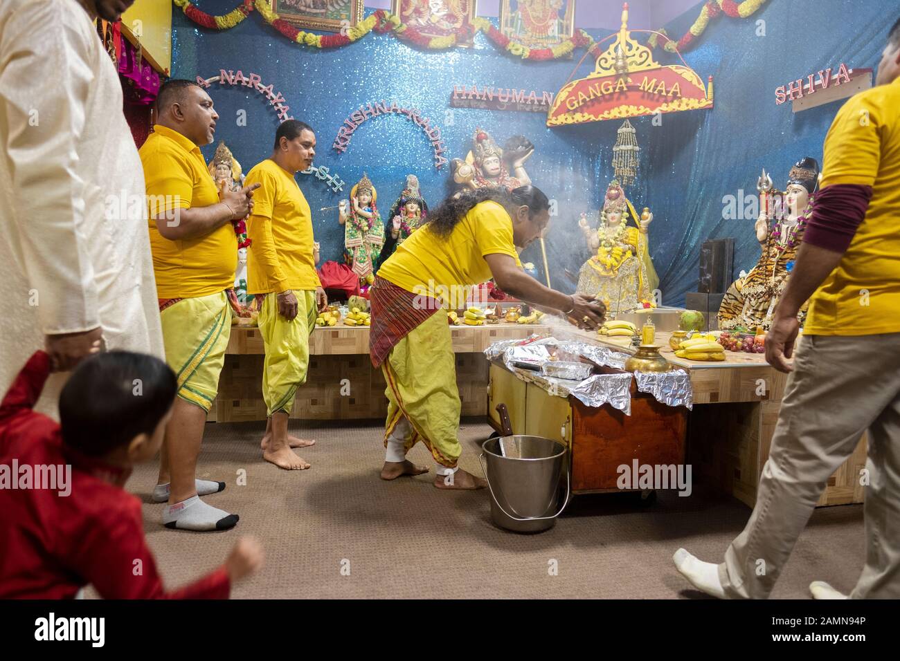 Un prêtre hindou fait une offrande de noix de coco aux divinités comme c'est une coutume dans l'hindouisme. Dans un temple en Jamaïque, Queens, New York City. Banque D'Images