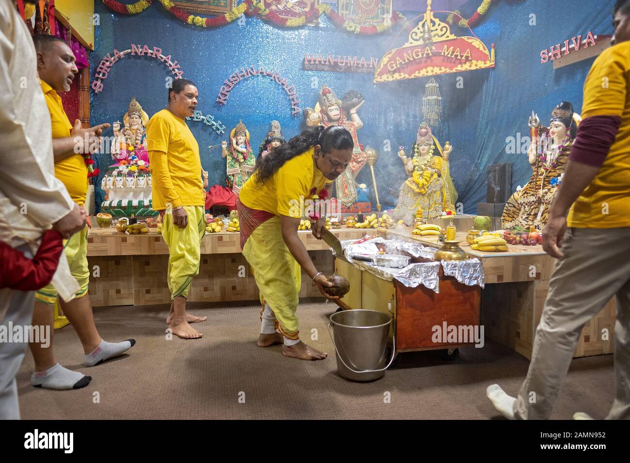 Un prêtre hindou fait une offrande de noix de coco aux divinités comme c'est une coutume dans l'hindouisme. Dans un temple en Jamaïque, Queens, New York City. Banque D'Images