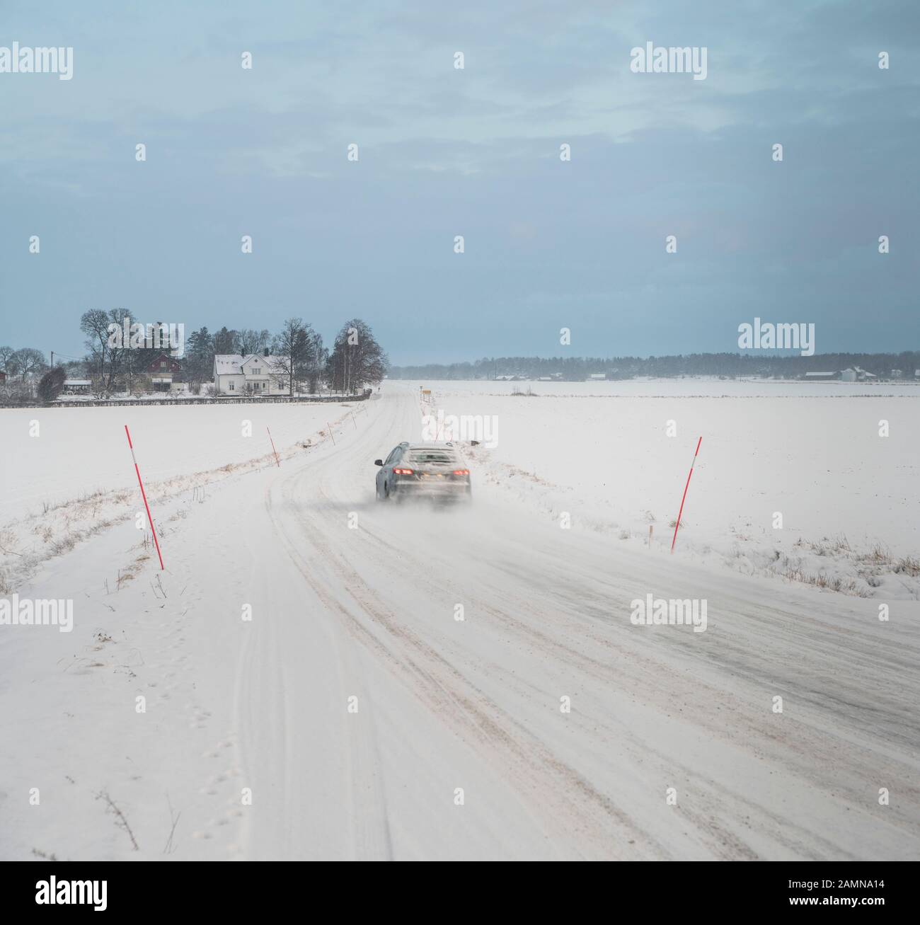 Voiture conduite sur route enneigée dans un paysage rural d'hiver, Suède, Scandinavie. Banque D'Images