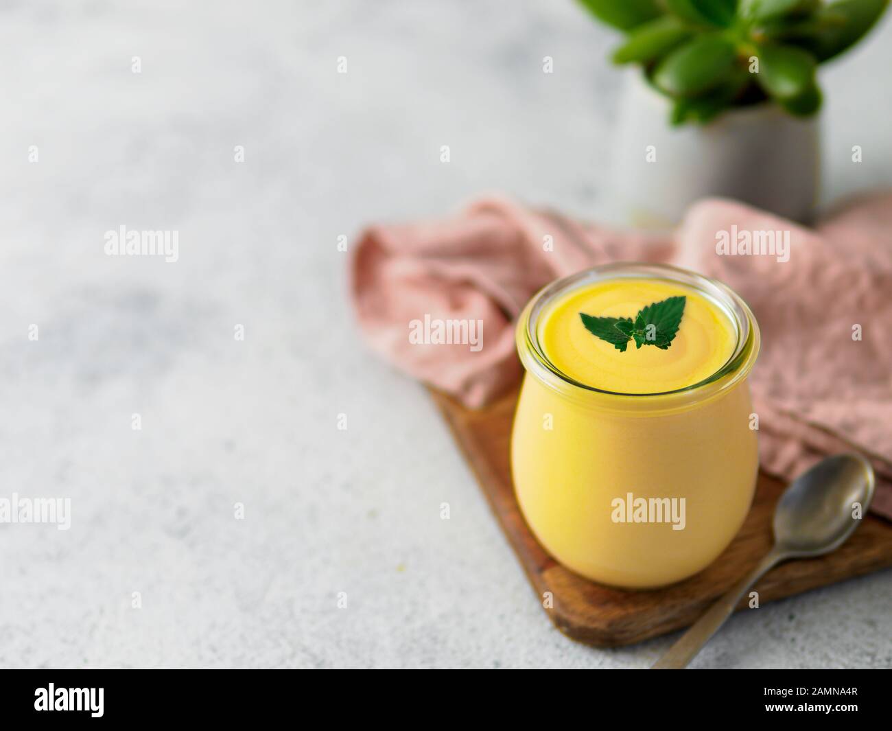 Lassi à la mangue jaune sur fond gris. Drink yaourt mangue indienne avec copie espace gauche. Banque D'Images