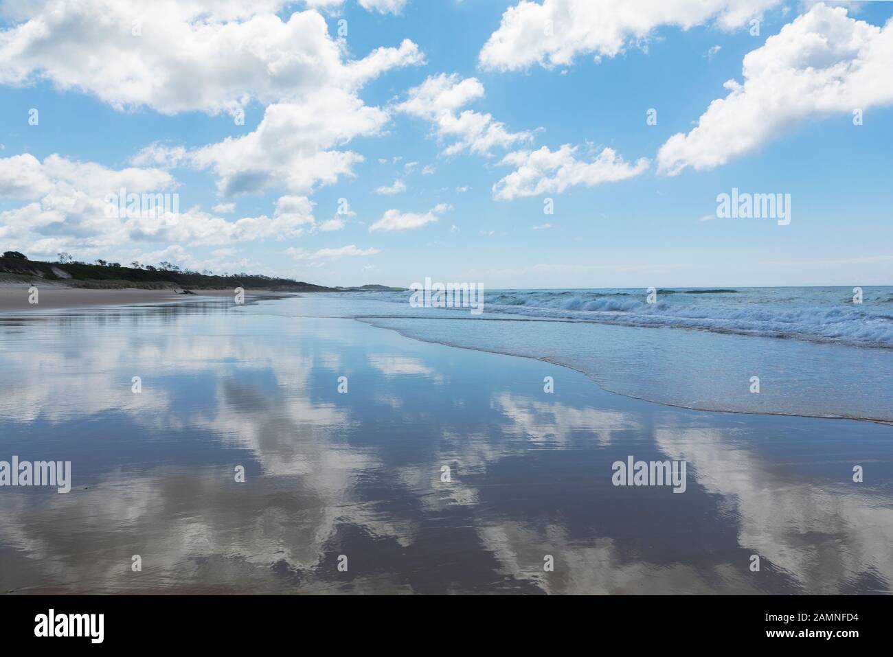 Australie, Yamba, Nouvelle-Galles du Sud, Pippi Beach, nuages reflétés dans le surf Banque D'Images