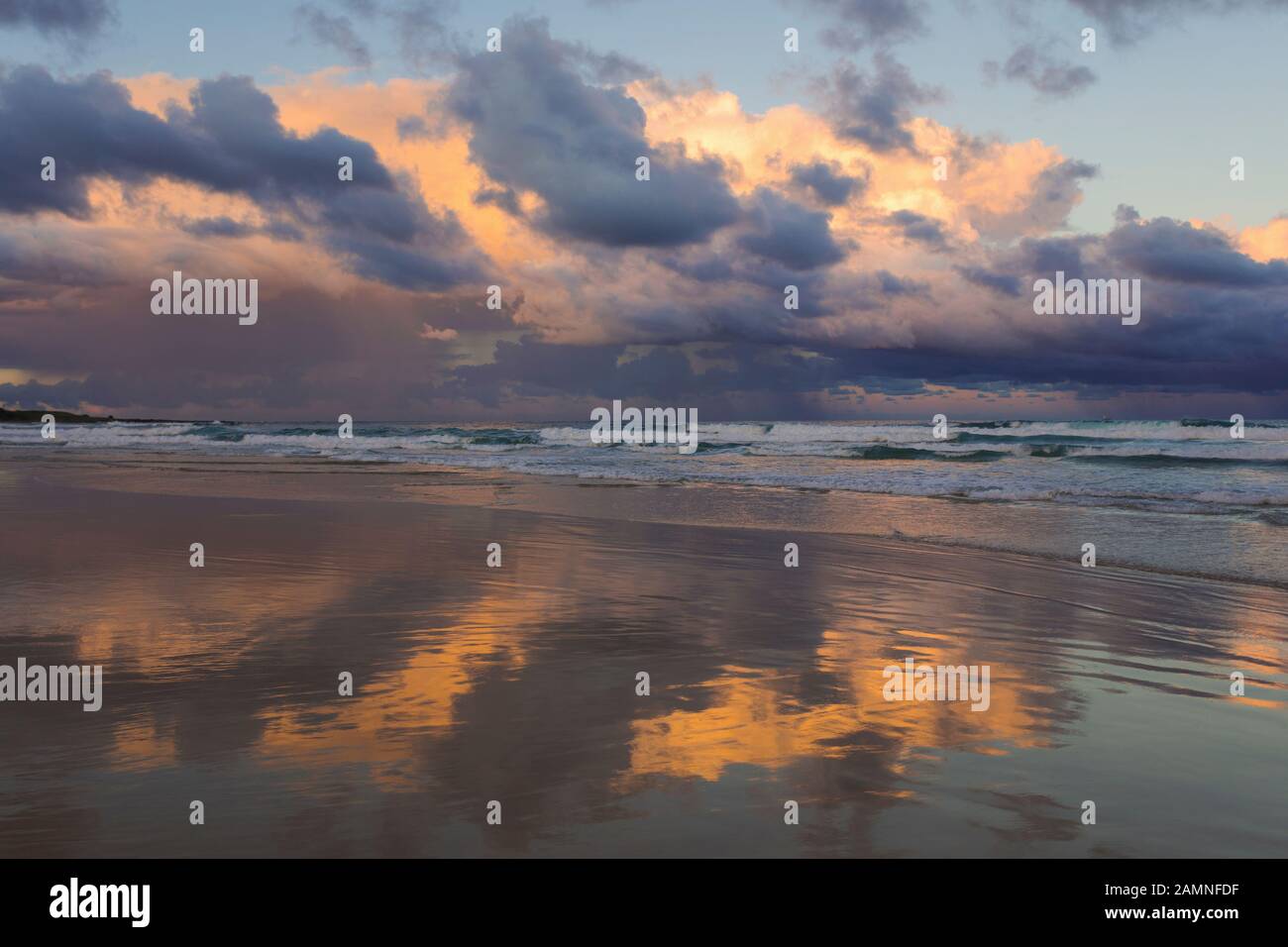 Australie, Yamba, Nouvelle-Galles du Sud, Pippi Beach, nuages reflétés dans le surf Banque D'Images