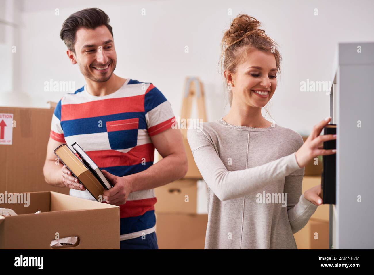 Jeune couple unpacking boxes in new flat Banque D'Images