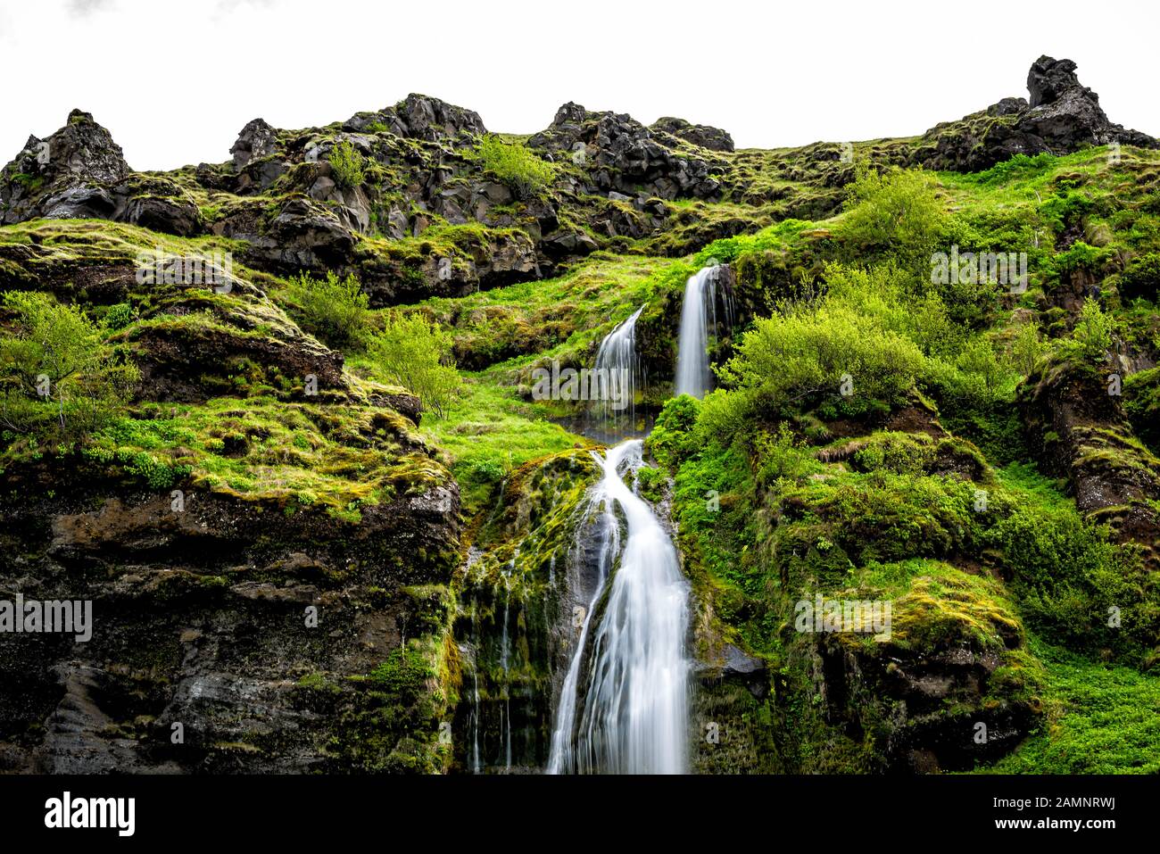 Gros plan sur la cascade Seljalandsfoss en Islande avec de l'eau qui tombe de la falaise dans la mousse verte été longue exposition fluide écoulement Banque D'Images