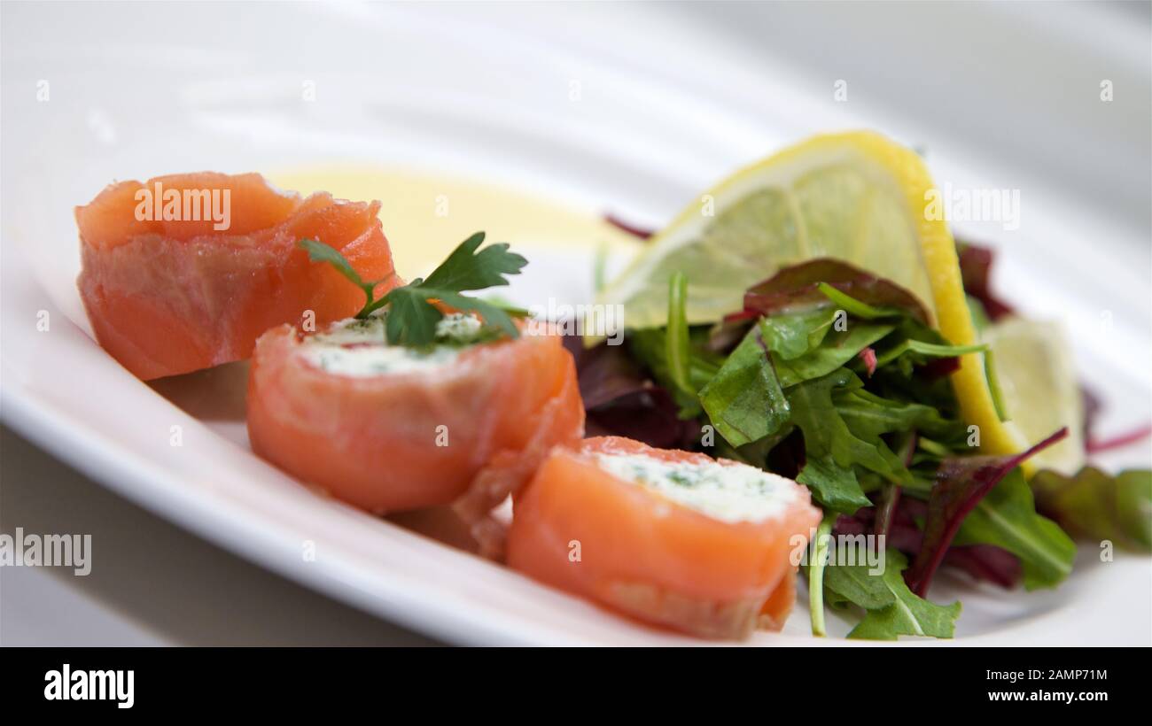 Un plat de départ de restaurant de saumon fumé roulé et de fromage à la crème. Banque D'Images