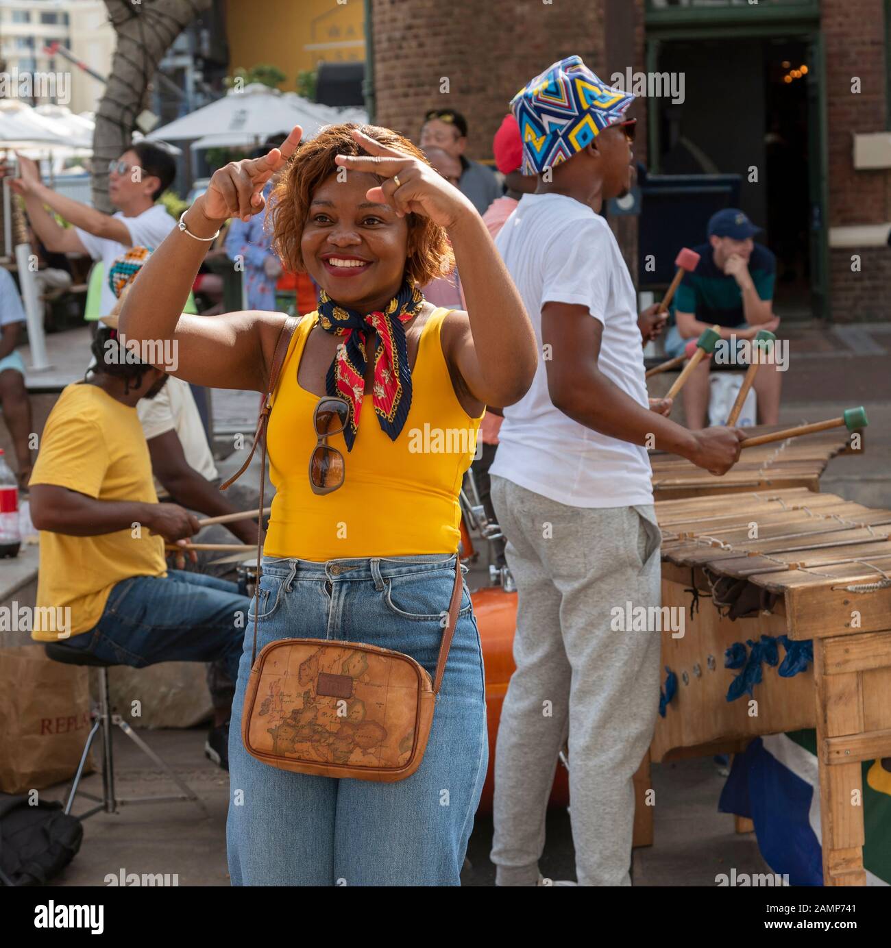 Le Cap, Afrique Du Sud. Décembre 2019. Musiciens de rue s'amuser avec un touriste dansant à la main sur le V&A Waterfront au Cap Banque D'Images