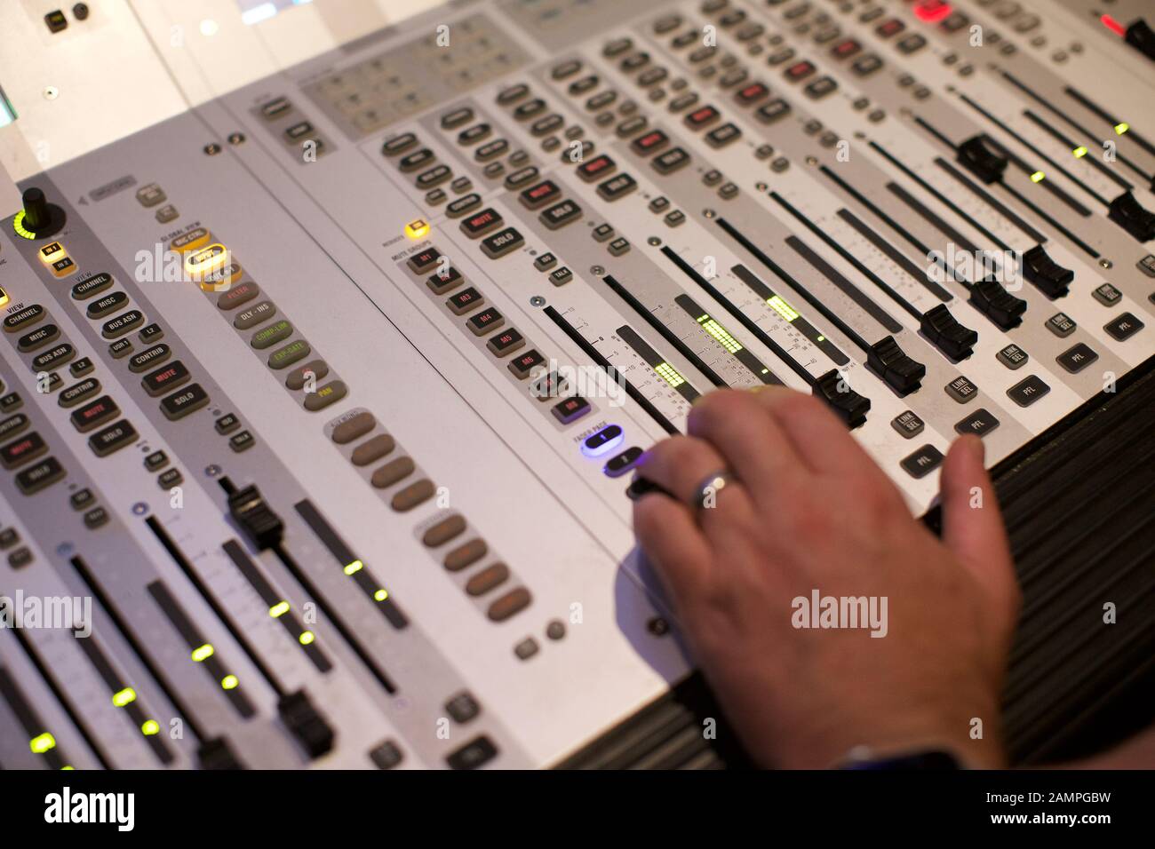 Close-up de la main d'un technicien déménagement un fader commutateur sur une console de mixage broadcast Banque D'Images