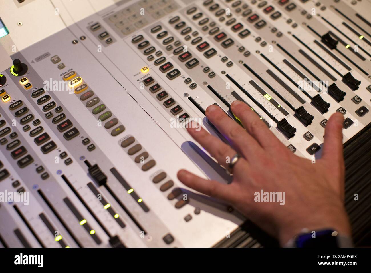 Close-up de la main d'un technicien déménagement un fader commutateur sur une console de mixage broadcast Banque D'Images