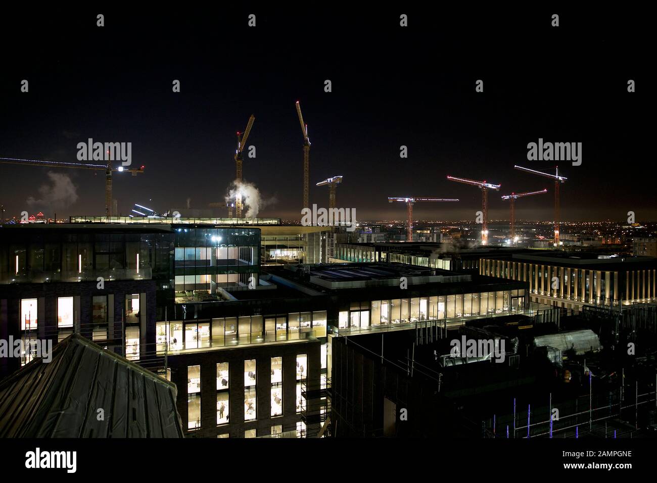 Les grues de construction sur les toits de Dublin illuminée pour Noël. Banque D'Images