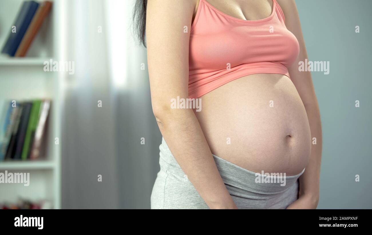 Femme enceinte au troisième trimestre posant pour la caméra, bonheur de la maternité Banque D'Images