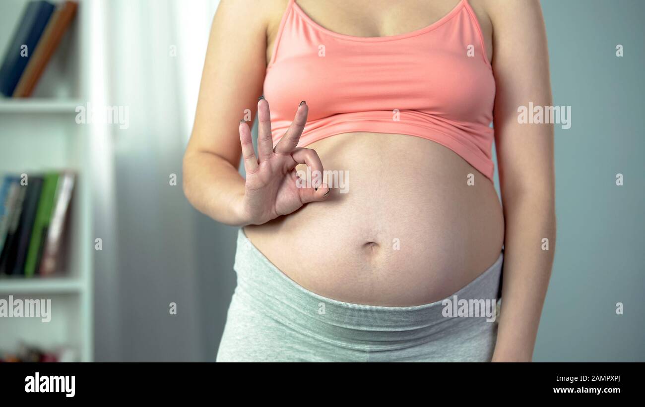 Femme enceinte montrant le signe ok, soins prénatals, bébé sain au troisième trimestre Banque D'Images