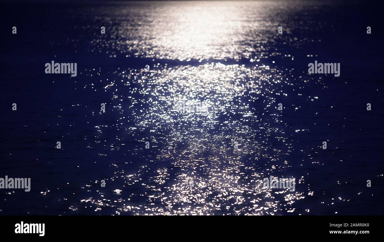 Magnifique lune romantique scintillant sur la surface de l'eau sombre, mer de nuit Banque D'Images